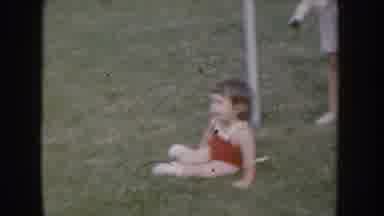 Nebraska USA (1955): Child In 1950'S Swimsuit Sitting In Grass Grass Near Two