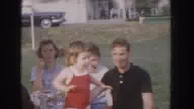 Nebraska USA (1955): Family On Vacation Encouraging Toddler In Red Swimming Suit