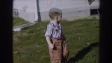 Nebraska USA (1956): A Little Boy Walking Outside In The Grass Of His Front Yard