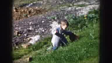 Nebraska USA (1956): Baby Walks On A Grass Cliff Showing Two Adults Standing And