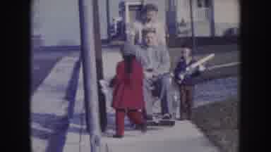 Nebraska USA (1957): Man Gets Pushed In Wheelchair While Grandkids Run About