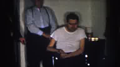 Nebraska USA (1957): An Elderly Man Sitting On A Couch Kisses A Boy While Other