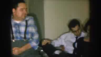 Nebraska USA (1957): Man Wearing Blue Shirt Suspenders Sitting In Chair Near