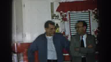 Nebraska USA (1957): Men Standing Talking In Red White Decorated Kitchen While