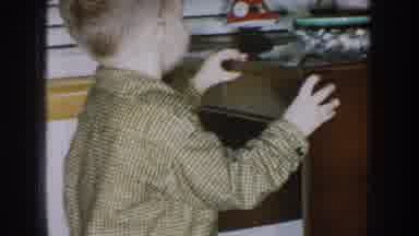 Nebraska USA (1957): A Child Taking Something Out Of A Bowl And A Grown Man
