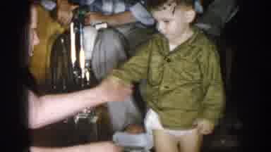 Nebraska USA (1957): Toddler Has His Clothes Checked By Mother And Goes On