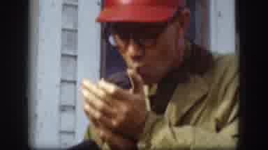 Kansas USA (1958): Man In A Red Hat And Glasses Lights A Cigar