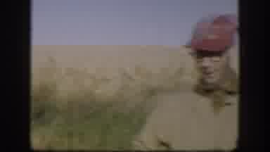 Kansas USA (1958): Men Wearing Red Hats,Tan Jackets Stand In Field Smoking
