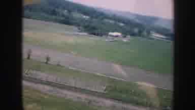 Nebraska USA (1958): Small Plane Pilot Flies Above Green Fields, Pine Trees, And