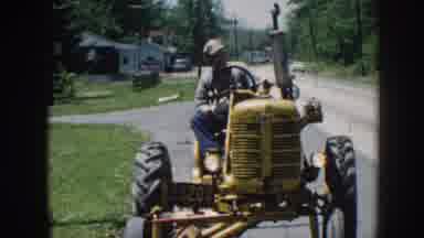 NEBRASKA USA-1958: Grandpa Driving Yellow Tractor To Town For Groceries