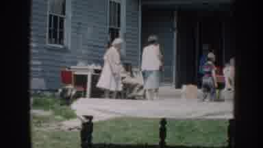 Nebraska USA (1958): A House Entrance With A Table On The Porch And Some People