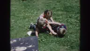 Nebraska USA (1958): Little Boys Play Fighting On A Garden