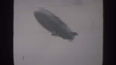 Nebraska USA (1958): A Blimp Flies Slowly Under An Overcast Sky During Daylight