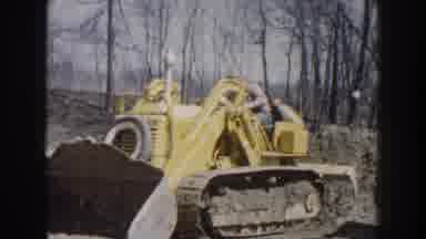 Nebraska USA (1959): Two Men Driving Yellow Bulldozers On A Clear Sunny Day