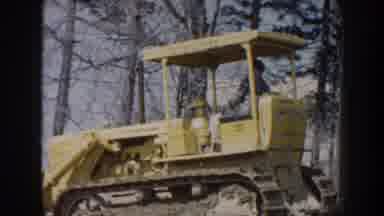 Nebraska USA (1959): Man Driving Yellow Bulldozer Tractor On A Bright Sunny Day