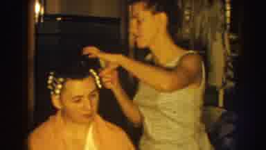Nebraska USA (1959): Woman Wearing Whites Placing Curlers In Hair Of Sitting Woman