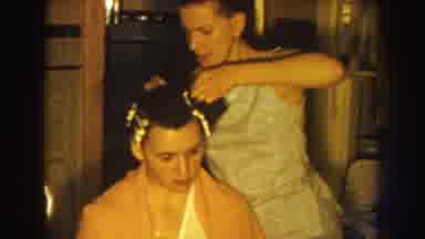 Nebraska USA (1959): Woman Wearing White Places Curlers In Hair Of Sitting Woman