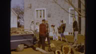 Nebraska USA (1959): Group Of People Gathering Around Chopped Up Pieces Of Wood