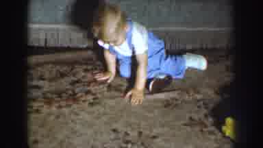 Nebraska USA (1959): Blonde Haired Baby Wearing Blue Suspender Pants Crawling And