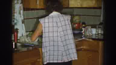 Nebraska USA (1959): A Woman In Plaid Preparing Something In A Kitchen And A Close