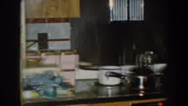 Nebraska USA (1959): Woman In The Kitchen With Pan On Fire