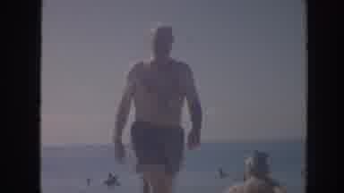 Hawaii USA (1961): Man Wearing Gray Shorts Walking On Beach On Sunny Day