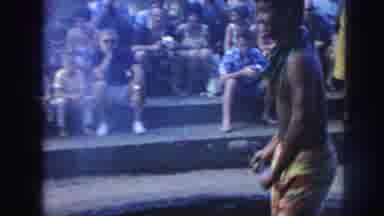 Hawaii USA (1961): Men Dressed In Colorful Clothes Work Together To Roast An