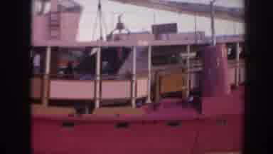 Hawaii USA (1961): A Pink Boat With People Walking Around The Decks At A Pier