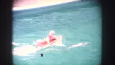 California USA (1962): Dog Wearing Red Shirt Riding In Model Speedboat View Of