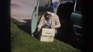Portland Oregon USA (1957): Someone Kneeling Near Box And Person In Blue Shirt
