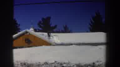 New Hampshire USA (1962): Man Clearing Snow From Roof On Bright Sunny Winter Day