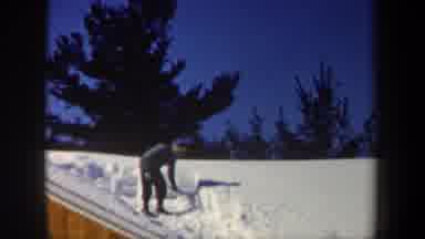 New Hampshire USA (1962): Man Shoveling Snow Off Of House After A Huge Snow Storm