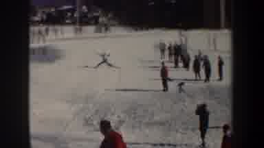 New York USA (1962): Skier Attempts A Jump And Wipes Out As People Look On
