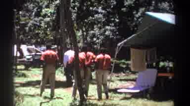 Kenya (1969): Four Red Shirt And One White Shirt Men Walk Outdoors Nearby Two Wild