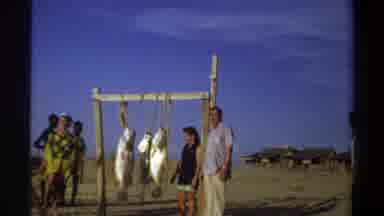 Nigeria (1969): Large Fish Hanging From A Setup With People Hanging Out