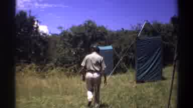 Lagos Nigeria (1969): Man Walk Turn Face Tent Tarps Field Grass Trees Sky