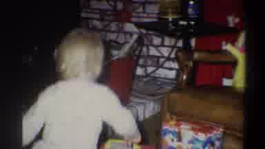 Troy New York USA (1973): Child Wearing White Runs To Look At Toys On Floor
