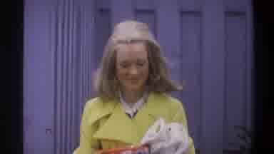 Troy New York USA (1973): 1970s Woman With Frosted Hair Holds Items As She Talks