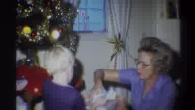 Troy New York USA (1973): A Young Blonde Boy Opens Opens A Present Near A