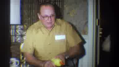 Troy New York USA (1973): Man Wearing Tan Shirt Glasses Points Toy At Child