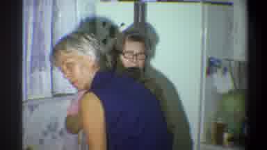 Troy New York USA (1973): Two Mature Women Work In The Kitchen Followed By A Young