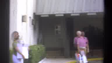 Troy New York USA (1973): Man And Woman In Green Shirt With Objects Stand Outside
