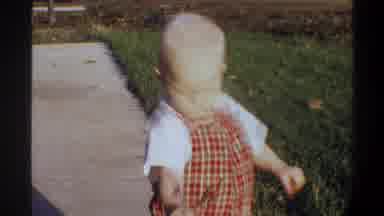 Gainsville Florida USA (1974): Child In Red Outfit Playing With A Yellow Toy Wheel