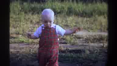 Gainsville Florida USA (1974): Infant Child Wearing Overalls Is Walking Curiously