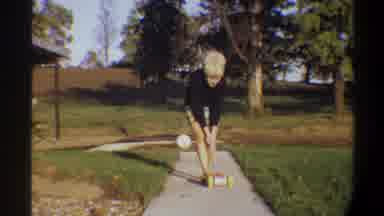 Gainsville Florida USA (1974): A Blonde Woman Is Pushing A Toy For A Child Along A