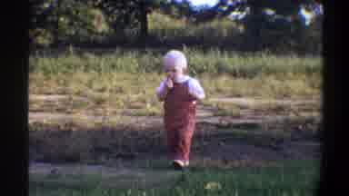 Gainsville Florida USA (1974): A Small Toddler Walks Aimlessly Among Some Dirt And