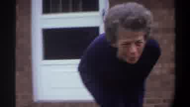 Gainsville Florida USA-1974: An Older Woman Picking Up An Infant Outside In