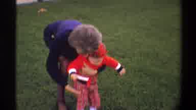Gainsville Florida USA (1974): Child In Red Clothes Being Hugged By An Elderly