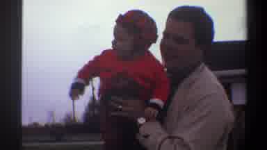 Gainsville Florida USA (1974): A Small Child Being Held By An Adult Male And Then