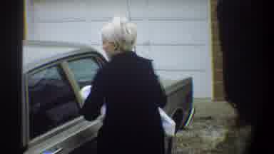 Gainsville Florida USA (1974): A Woman Getting Off Car Closing Door While Holding